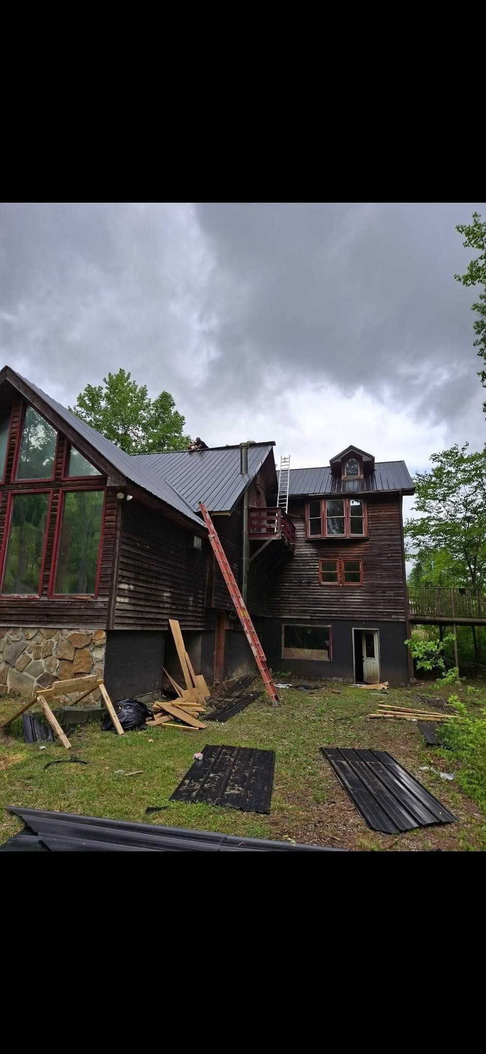 A large wooden house with a ladder on the side of it.