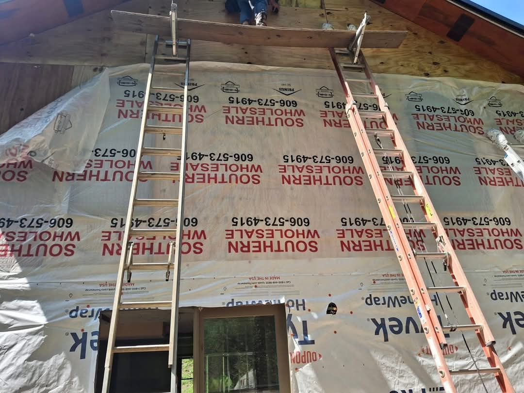 A ladder is hanging from the side of a building covered in southern wrap