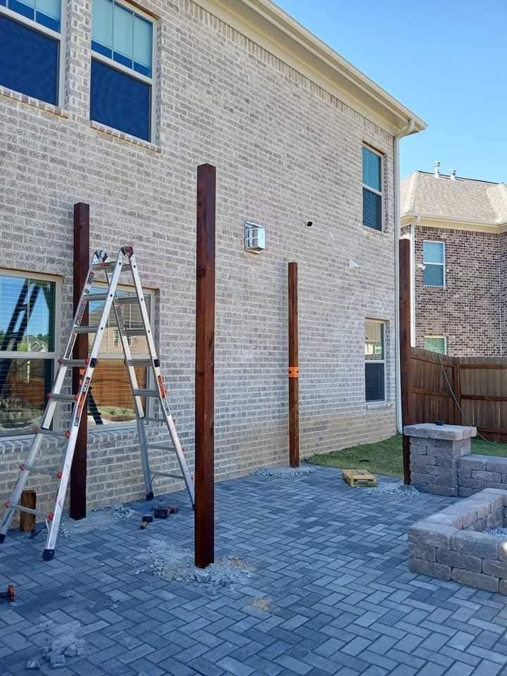 A ladder is sitting in front of a brick building.