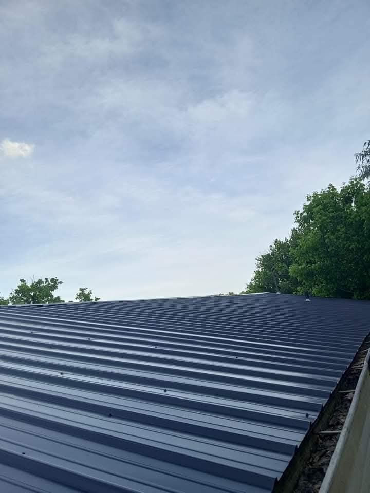 A black metal roof with a blue sky in the background.