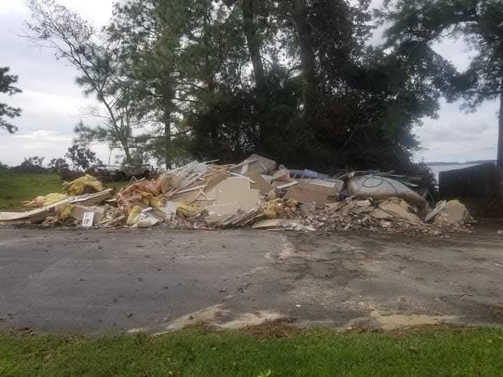 There is a large pile of trash on the side of the road.
