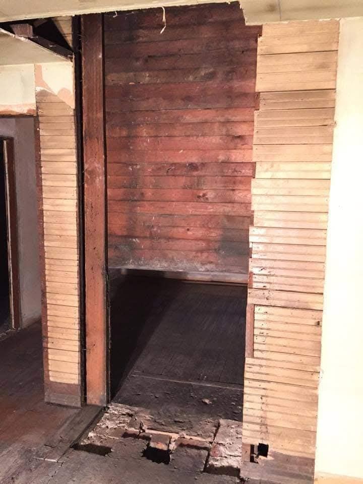 A room with a wooden wall and a brick wall.