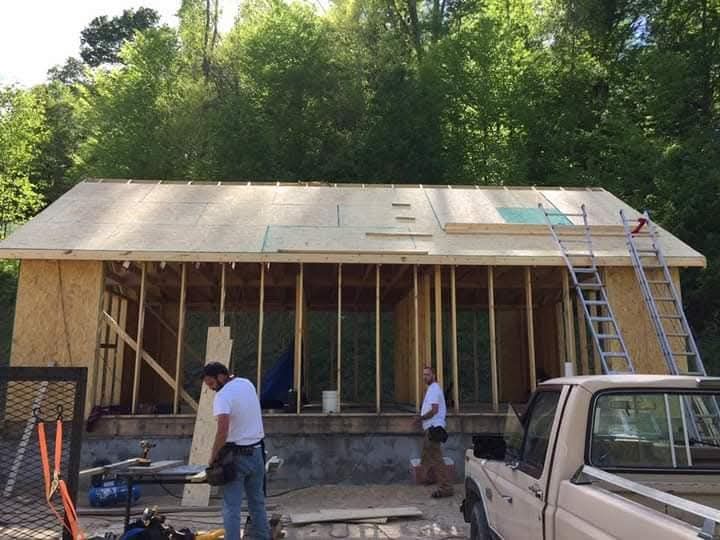 A truck is parked in front of a house under construction