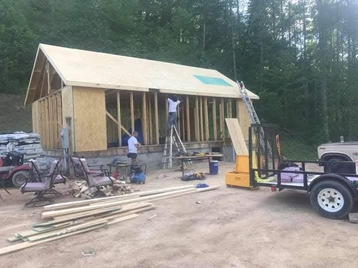 A trailer is parked in front of a house being built.