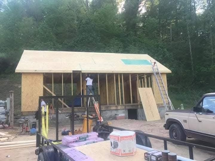 A truck is parked in front of a house under construction.