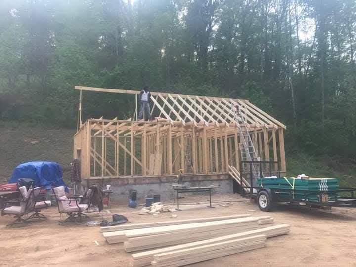 A wooden structure is being built in the middle of a forest.