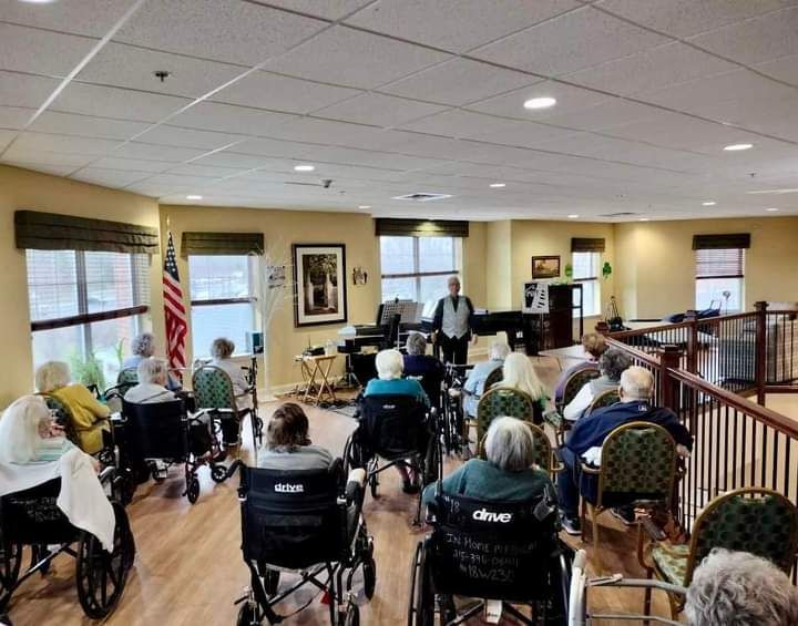 A group of people in wheelchairs are sitting in a room