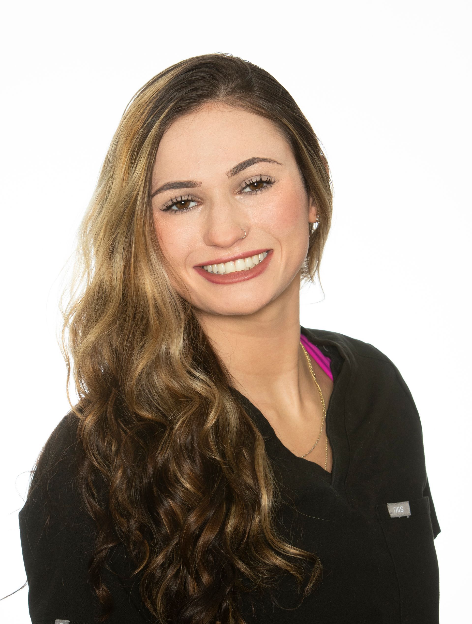 A woman with long hair is smiling and wearing a black shirt.