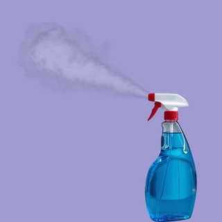 Blue spray bottle emitting a plume of mist against a purple background.