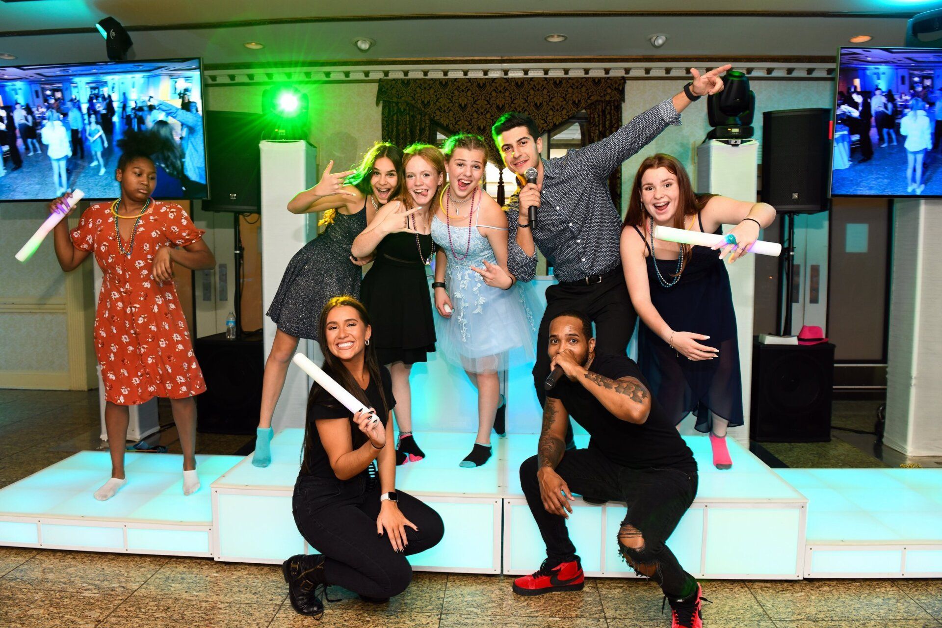 Bar Mitzvah djs, motivators and mcs  posing with guests on DJ stage.