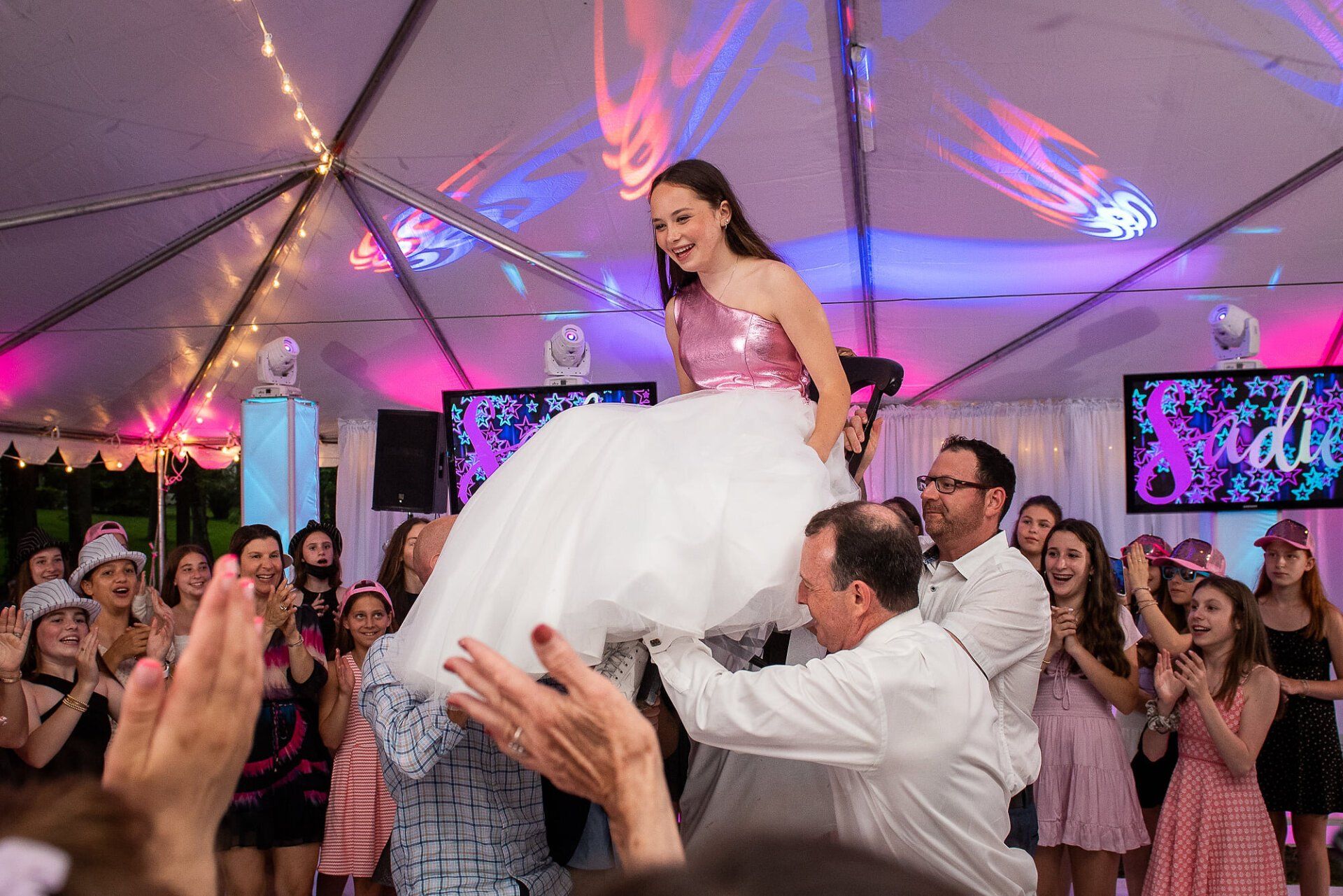 Bat Mitzvah outdoor party with guests surrounding a chair lift ceremony.
