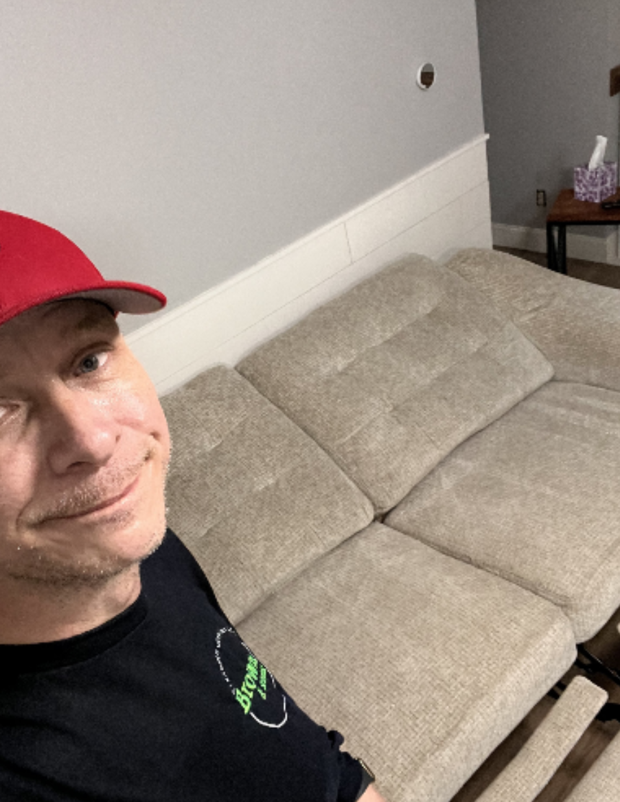 A man wearing a red hat is sitting on a couch.