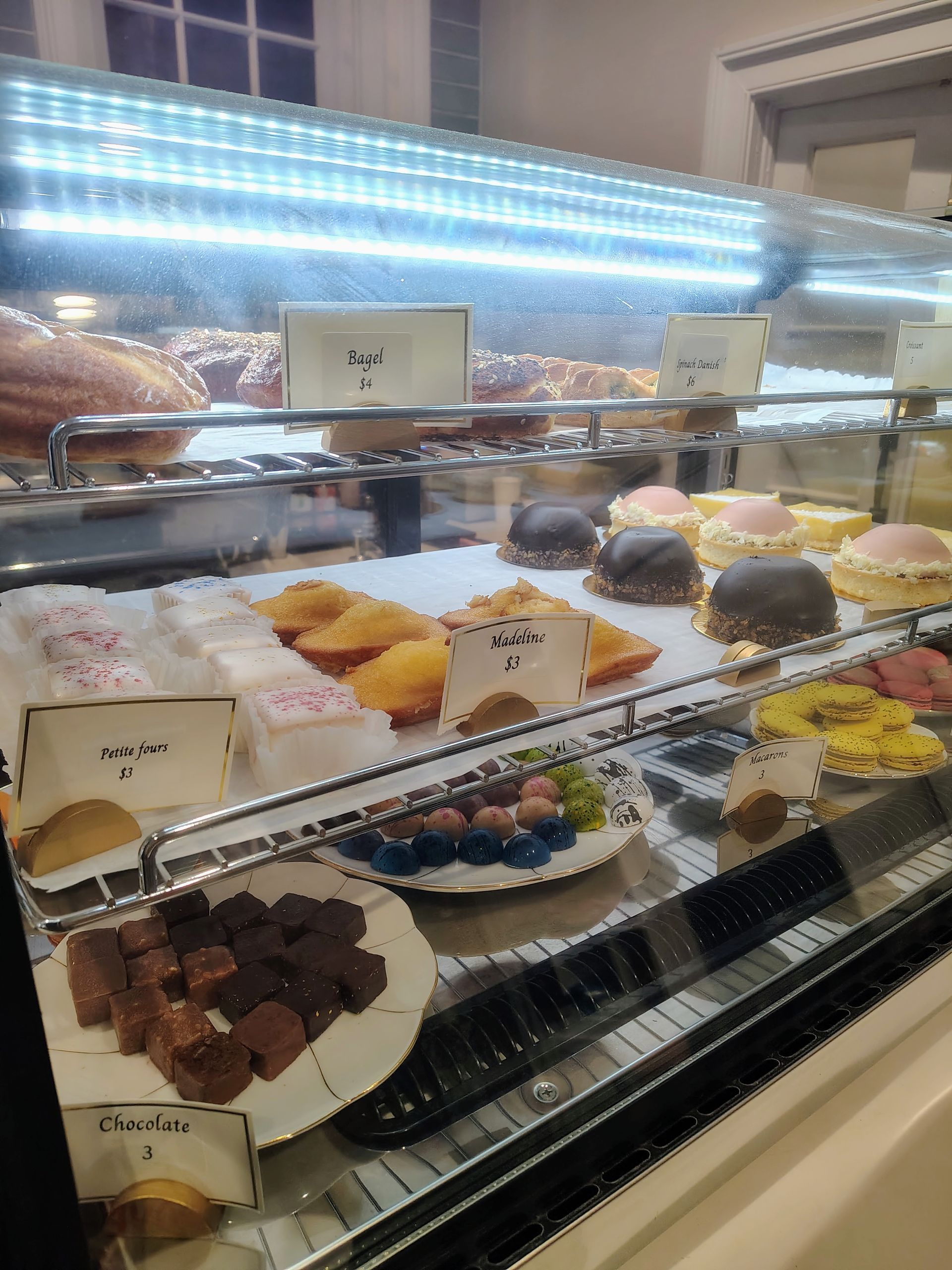 Bakery display case with various pastries, including cakes, chocolates, and cookies.