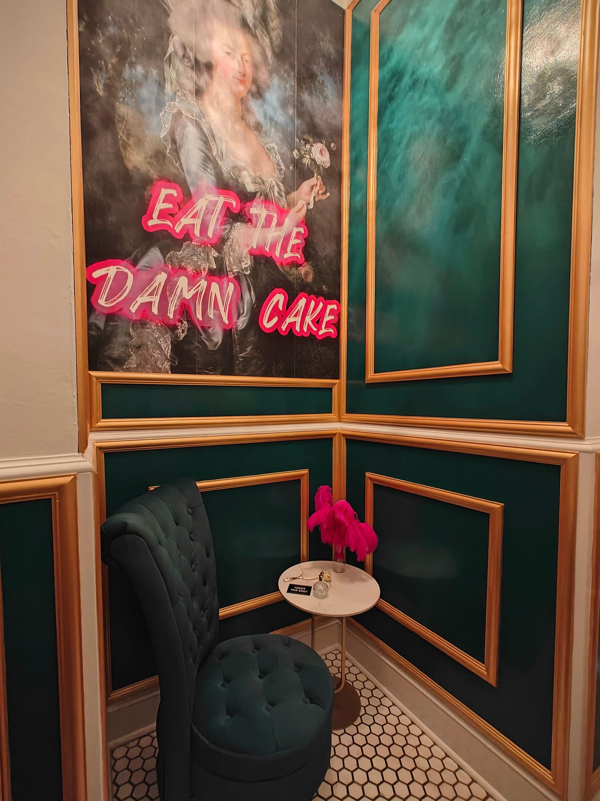 Corner with turquoise walls, gold trim, and a portrait reading 