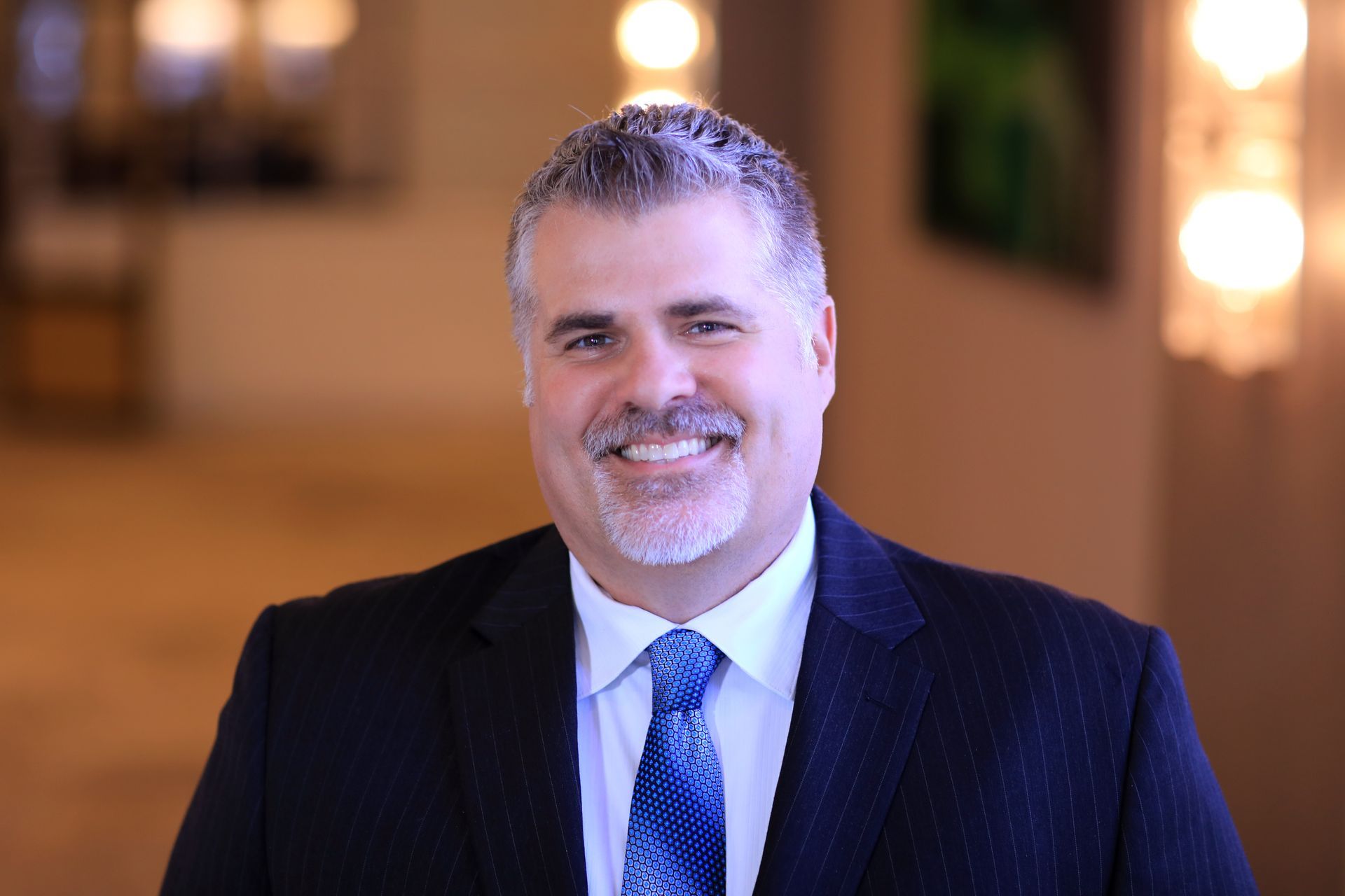 A man in a suit and tie is smiling for the camera.