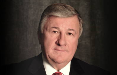 A man in a suit and tie looks at the camera