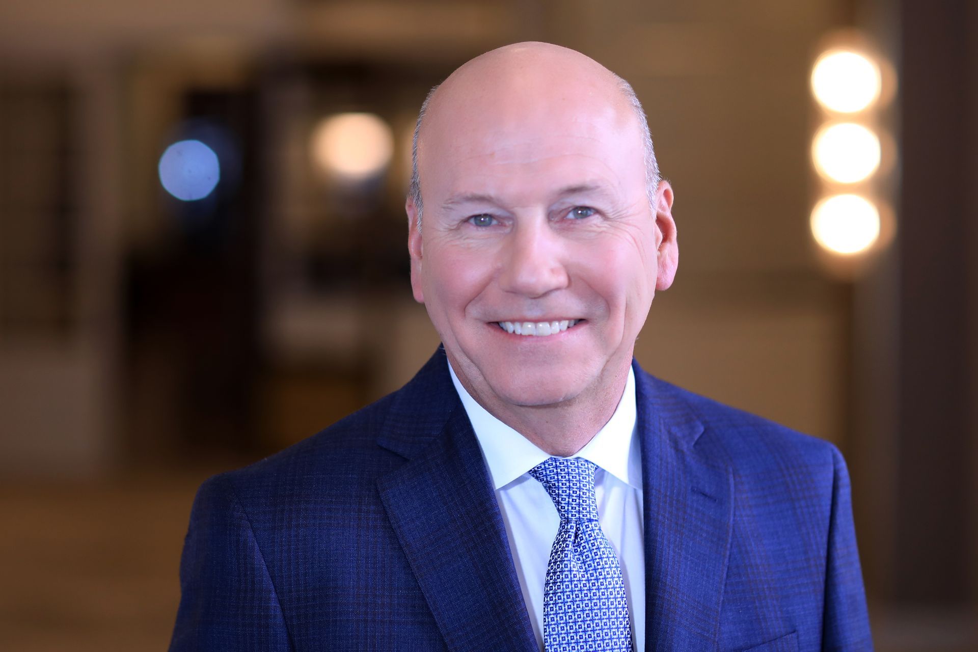 A man in a suit and tie is sitting on a blue couch.
