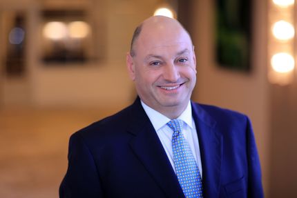 A man in a suit and tie is smiling for the camera
