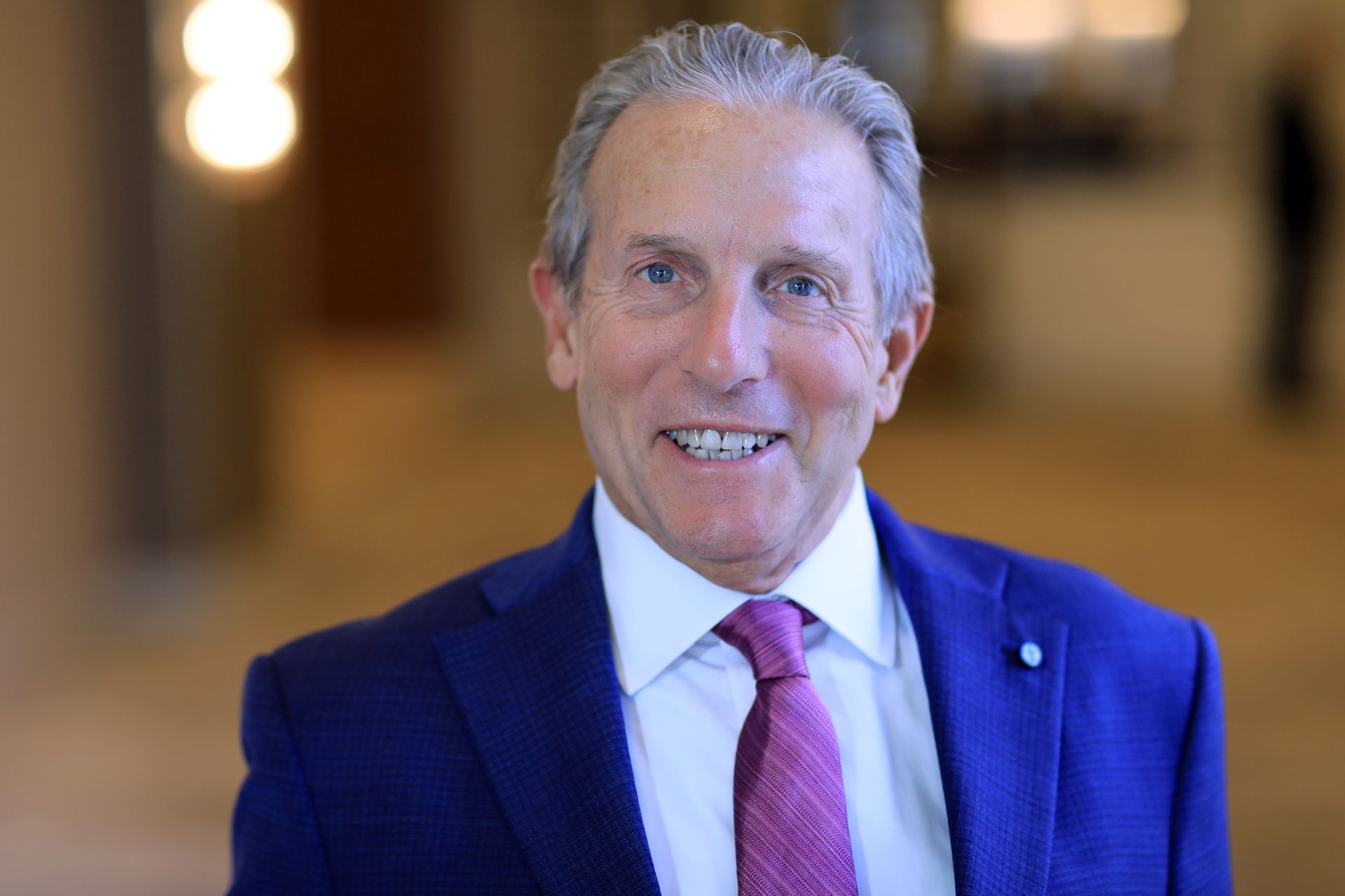 A man in a suit and tie is smiling for the camera.