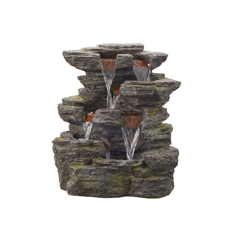 Rock-shaped water fountain with multiple tiers, water flowing down. Grey rocks, brown accents.