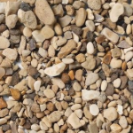 Small, multicolored river rocks scattered. Browns, tans, and grays create a natural texture.