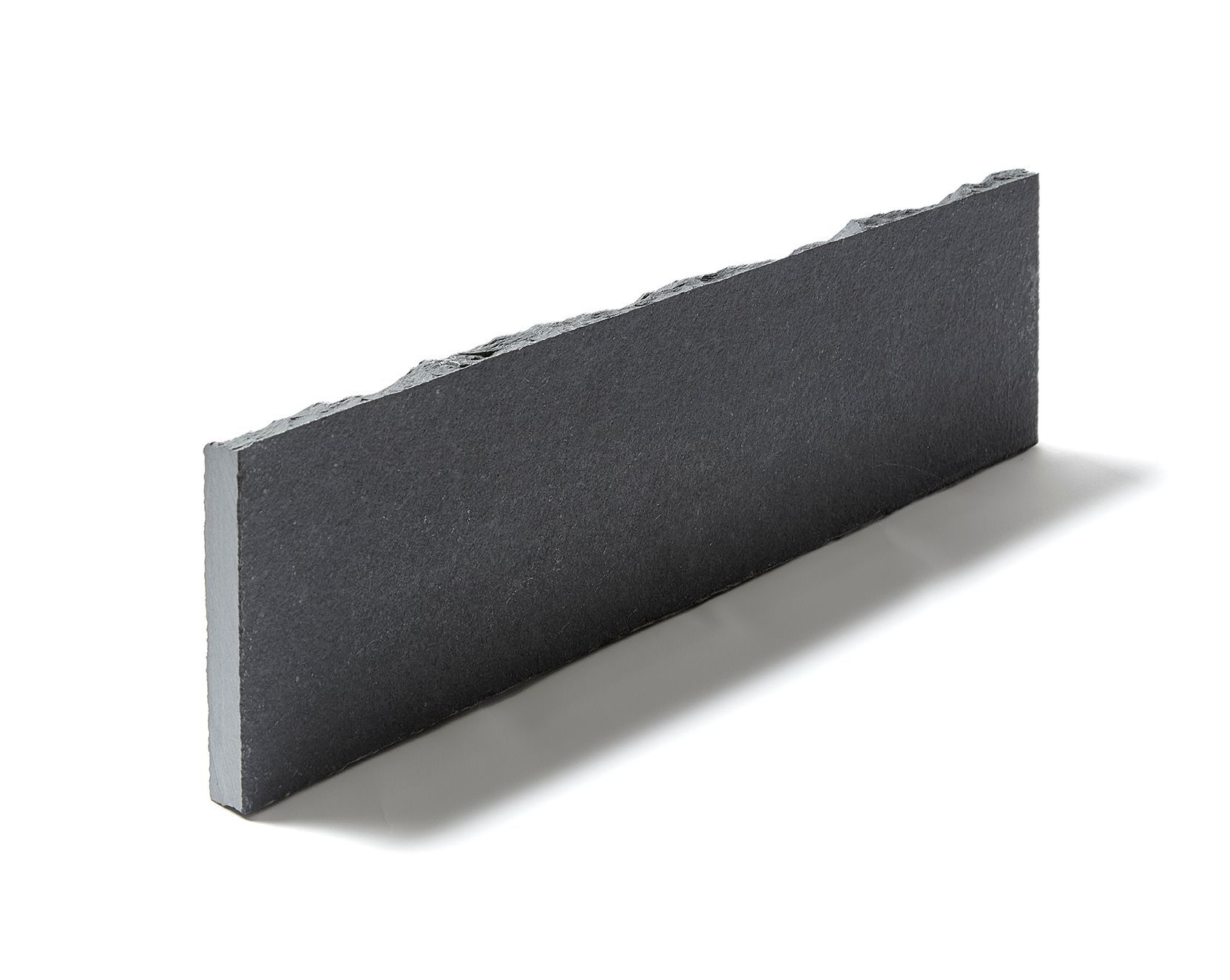 Dark gray rectangular stone with a rough edge.