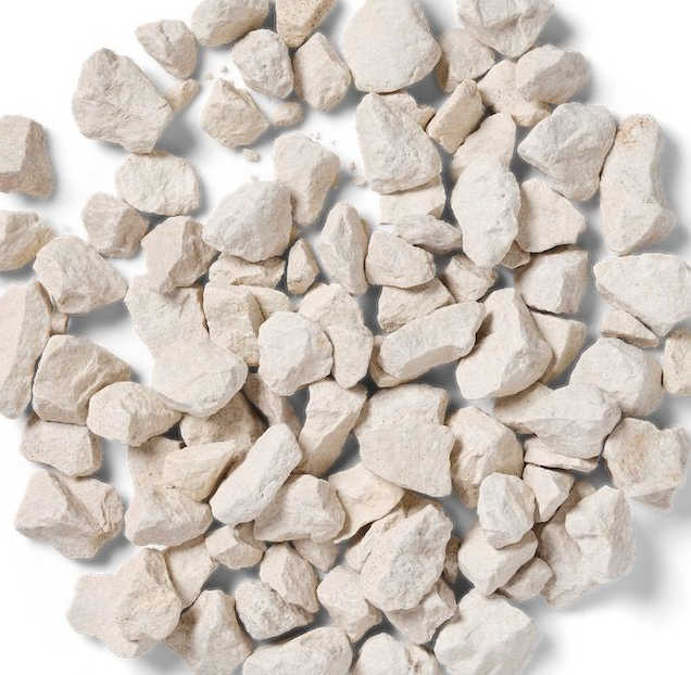 White decorative gravel stones, roughly textured, scattered on a white surface.
