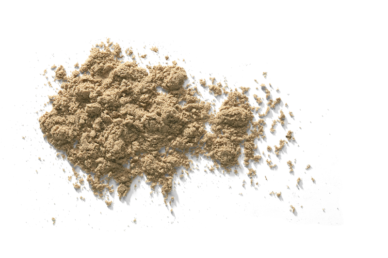 Pile of light brown powder on a white surface, with some powder scattered.