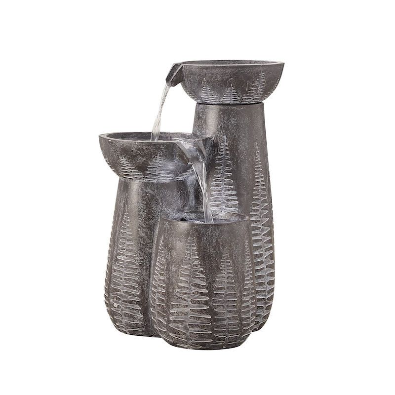 Three-tiered outdoor water fountain with textured gray finish; water flowing from top tier to bottom.