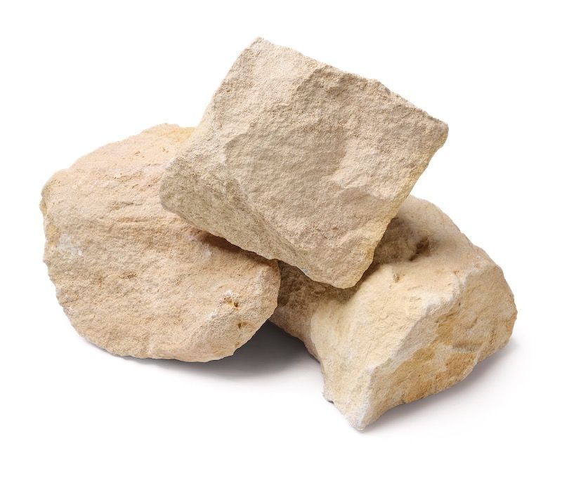 Tan-colored, irregularly shaped rocks stacked against a white background.