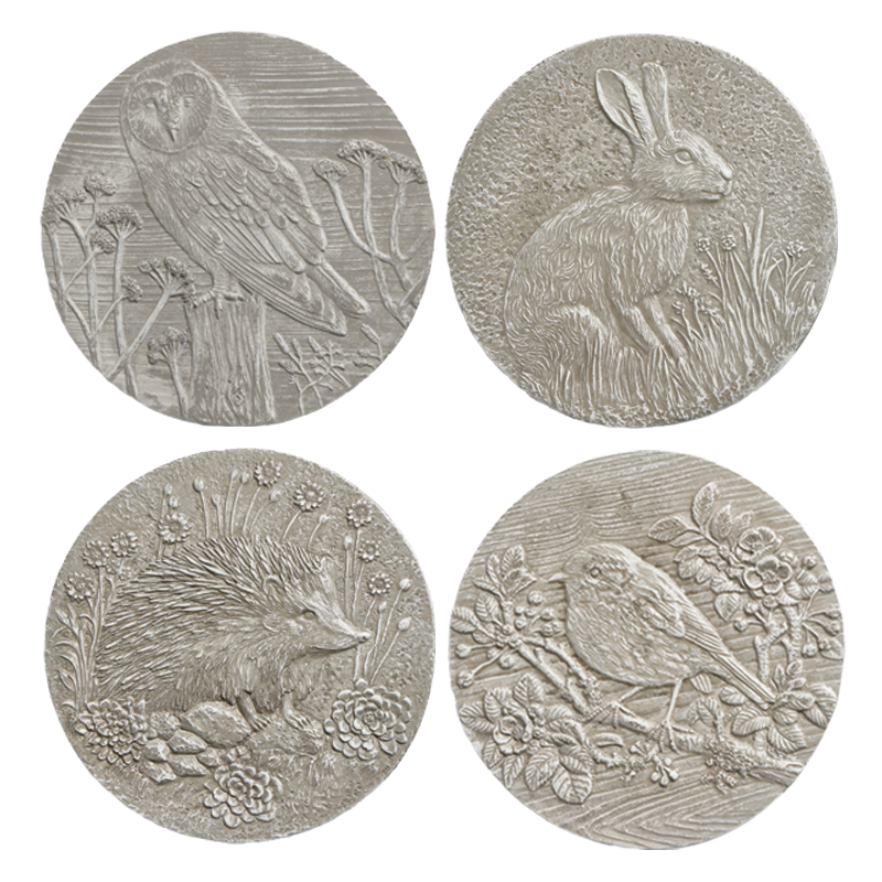 Four silver-toned circular medallions: owl, rabbit, hedgehog, and bird, each in a natural setting.