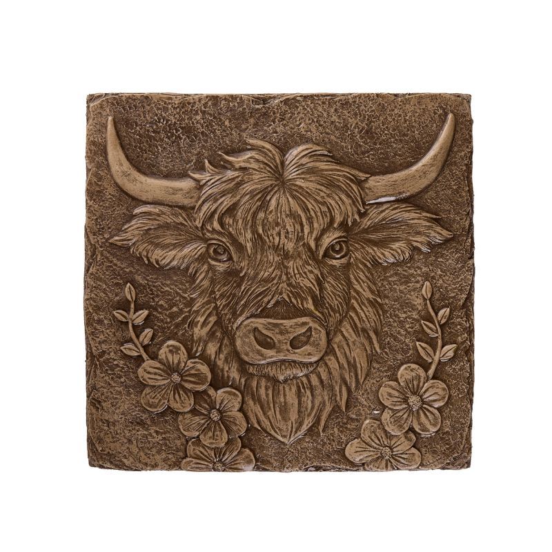Brown relief sculpture of a Highland cow with curved horns and flowers.