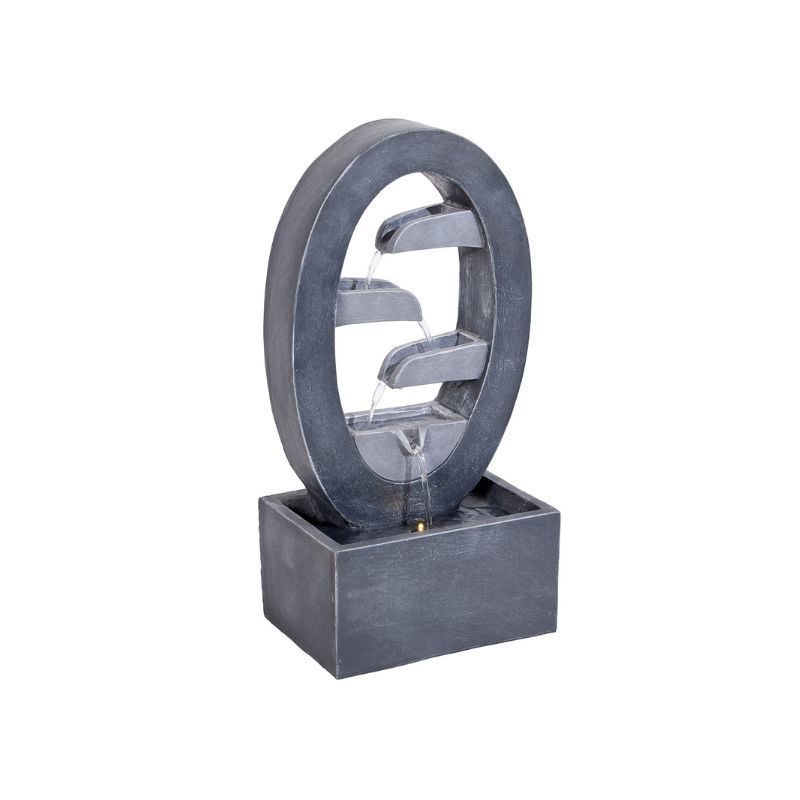 Indoor water fountain with oval frame, water cascading from three tiers into a rectangular base.