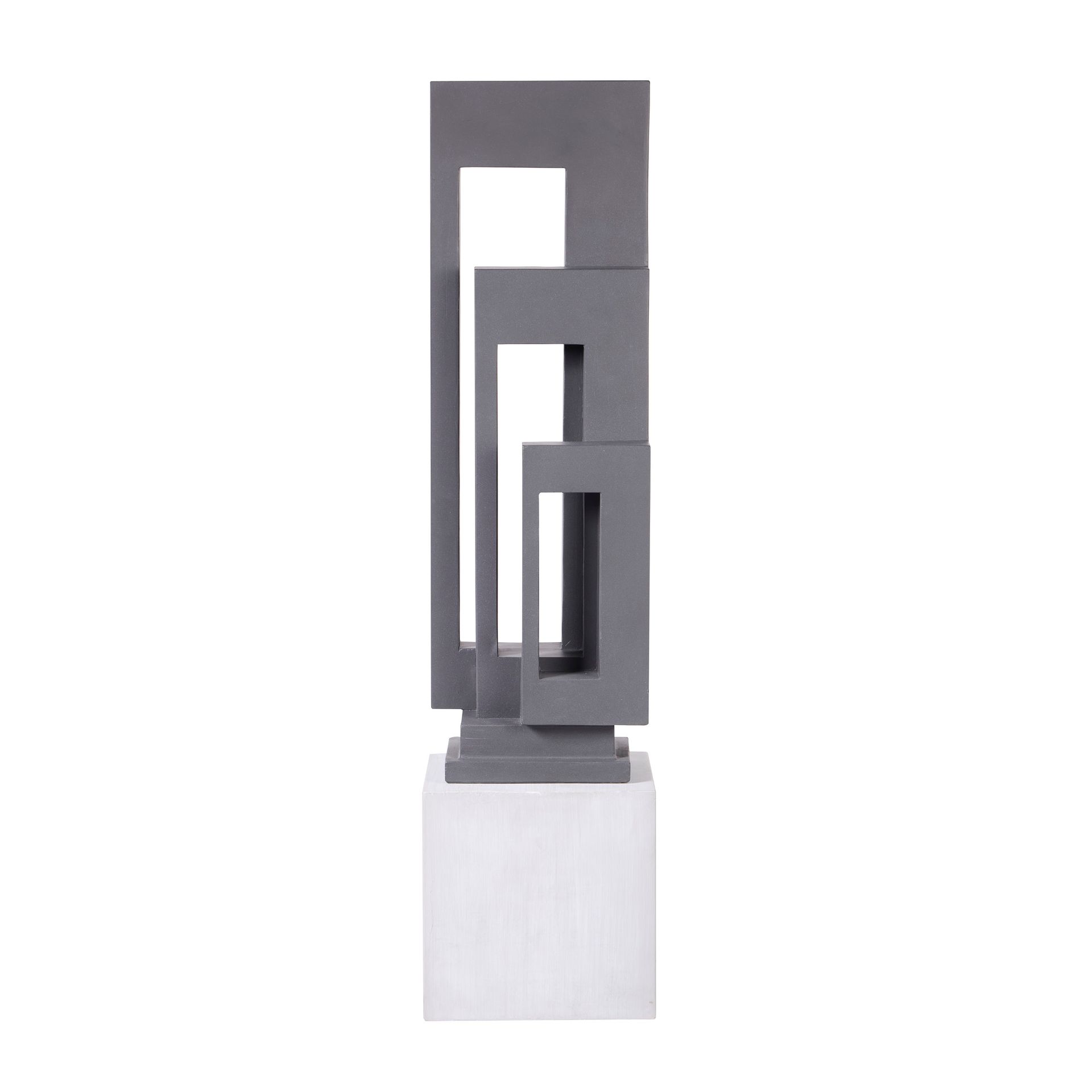 Gray abstract sculpture of rectangular shapes on a white base.
