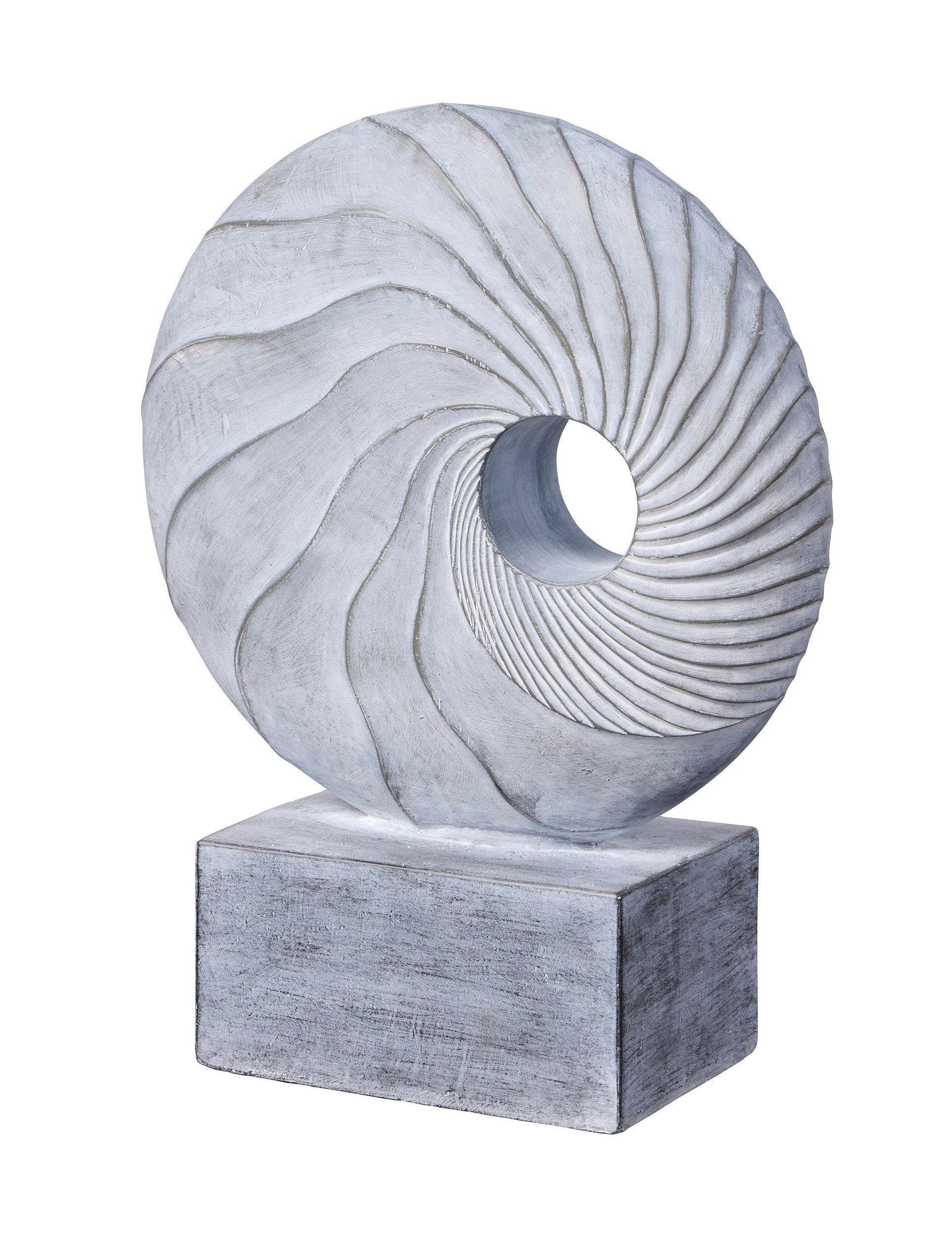 Stone sculpture of a torus with swirling lines, atop a rectangular base.