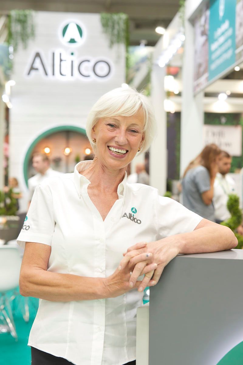 Woman smiling, leaning on a display with 