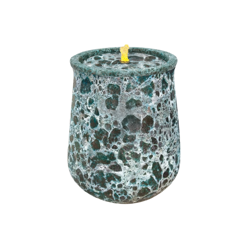Teal speckled candle in a round, textured glass jar with a yellow wick.