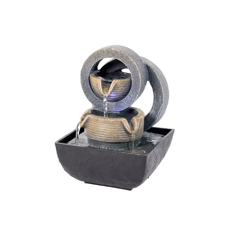 Indoor water fountain with a circular design, grey and tan colors, water flowing.