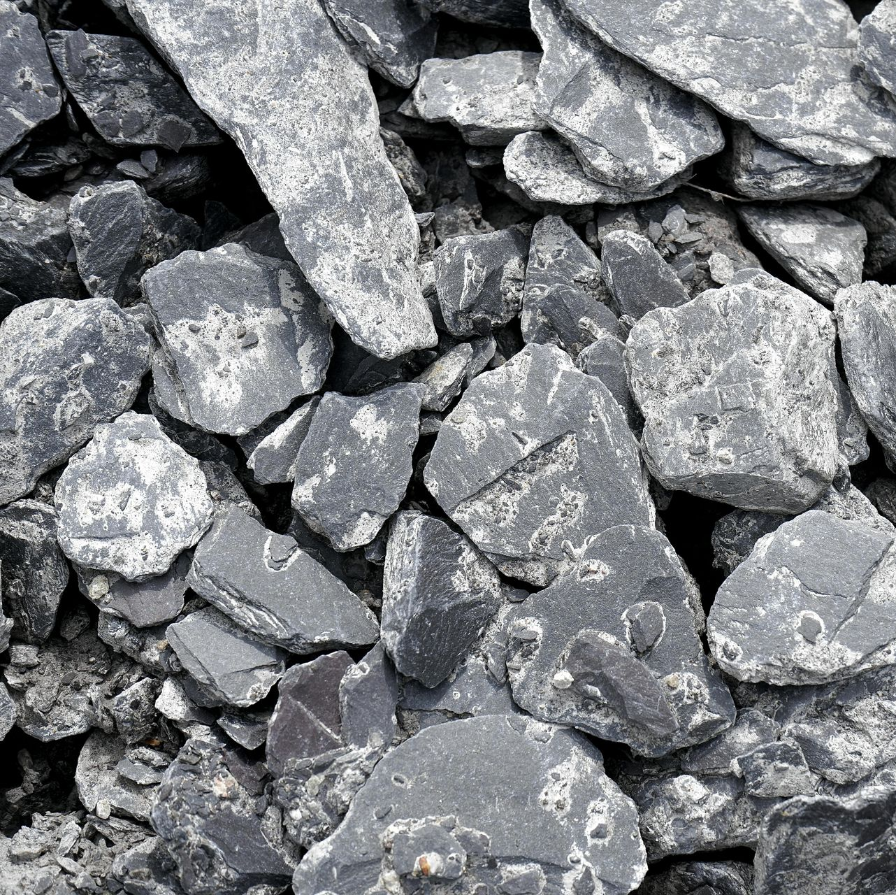 Pile of dark gray and white crushed rock.