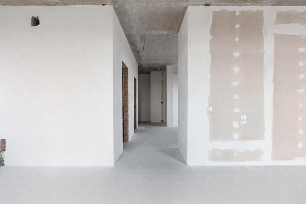 An empty room with white walls and a concrete floor.