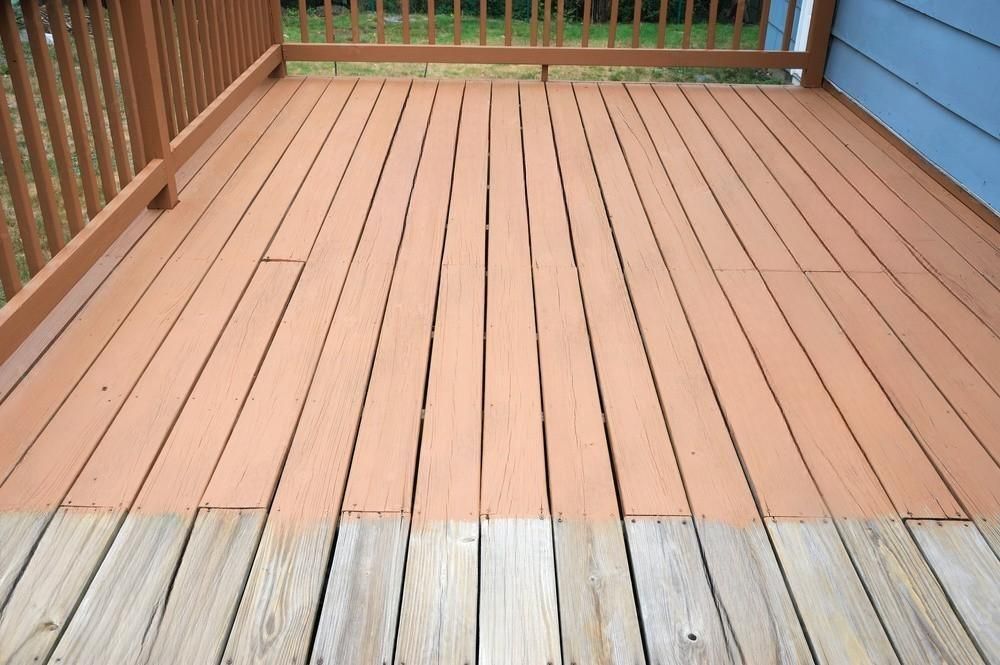 A wooden deck with a blue house in the background