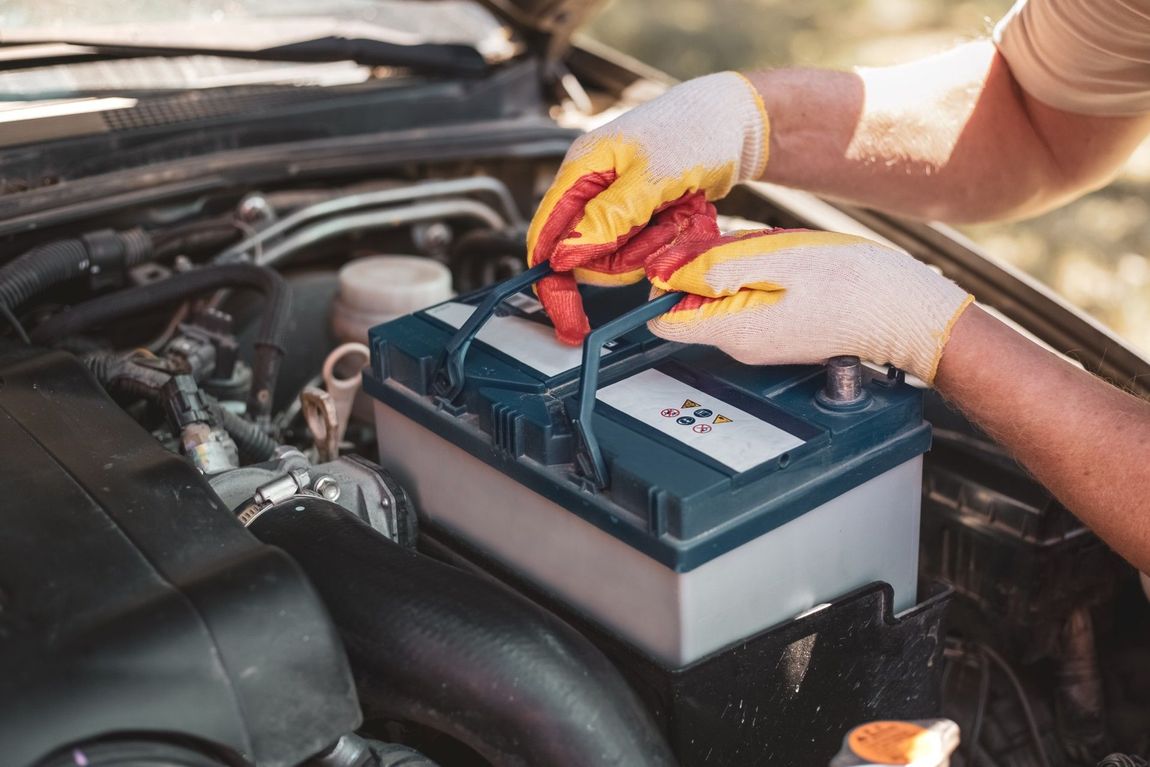 A person is plugging a battery into a car.