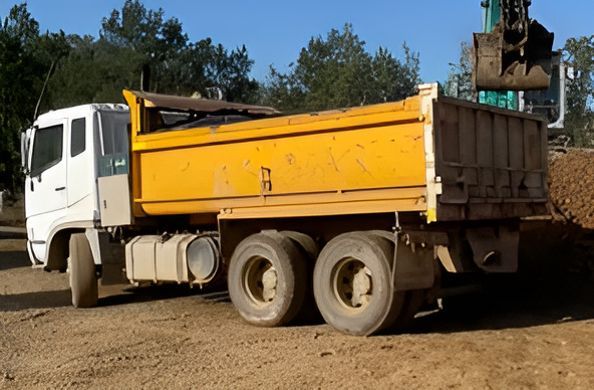 A Yellow Dump Truck Is Parked Next To A White Truck — GCE Earthworks Pty Ltd In Krambach, NSW