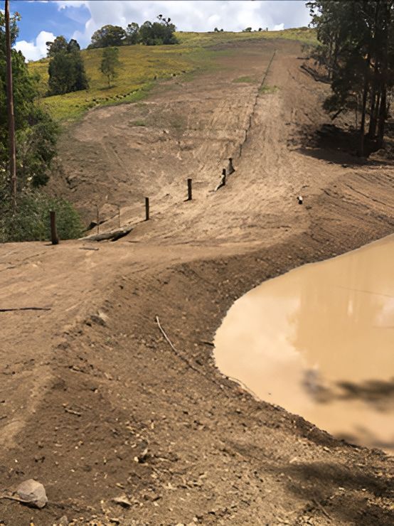 A Bulldozer Is Driving Down A Dirt Road — GCE Earthworks Pty Ltd In Krambach, NSW