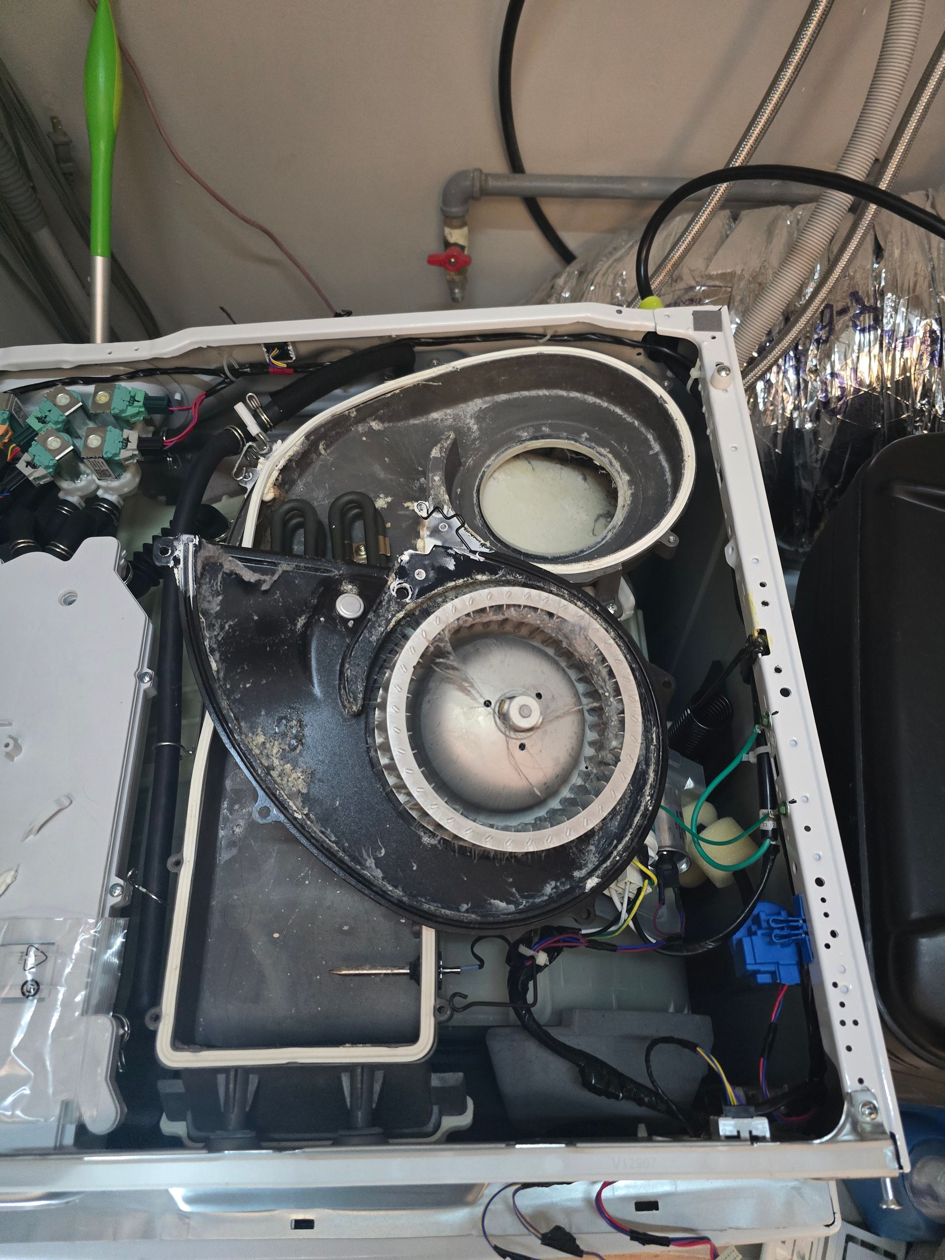 Interior of a machine with a fan and electrical components, white and black colors, against a light background.