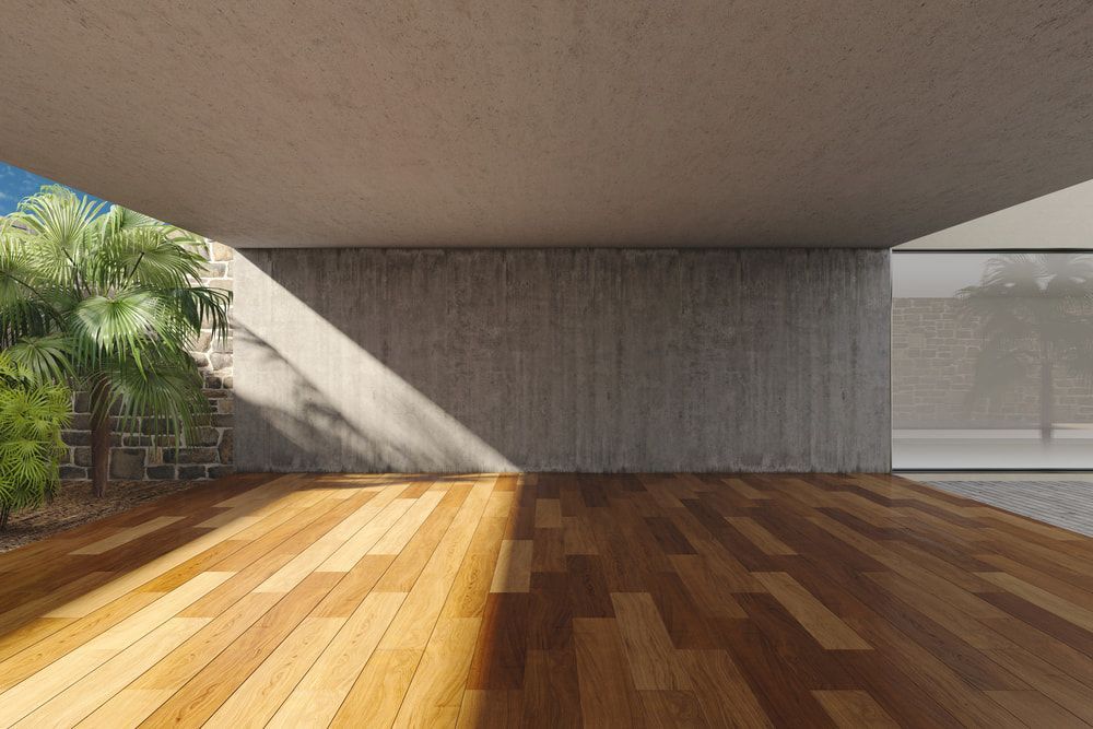 An Empty Room With A Wooden Floor And A Concrete Wall — Johnson's Timber Agencies In Ulladulla, NSW