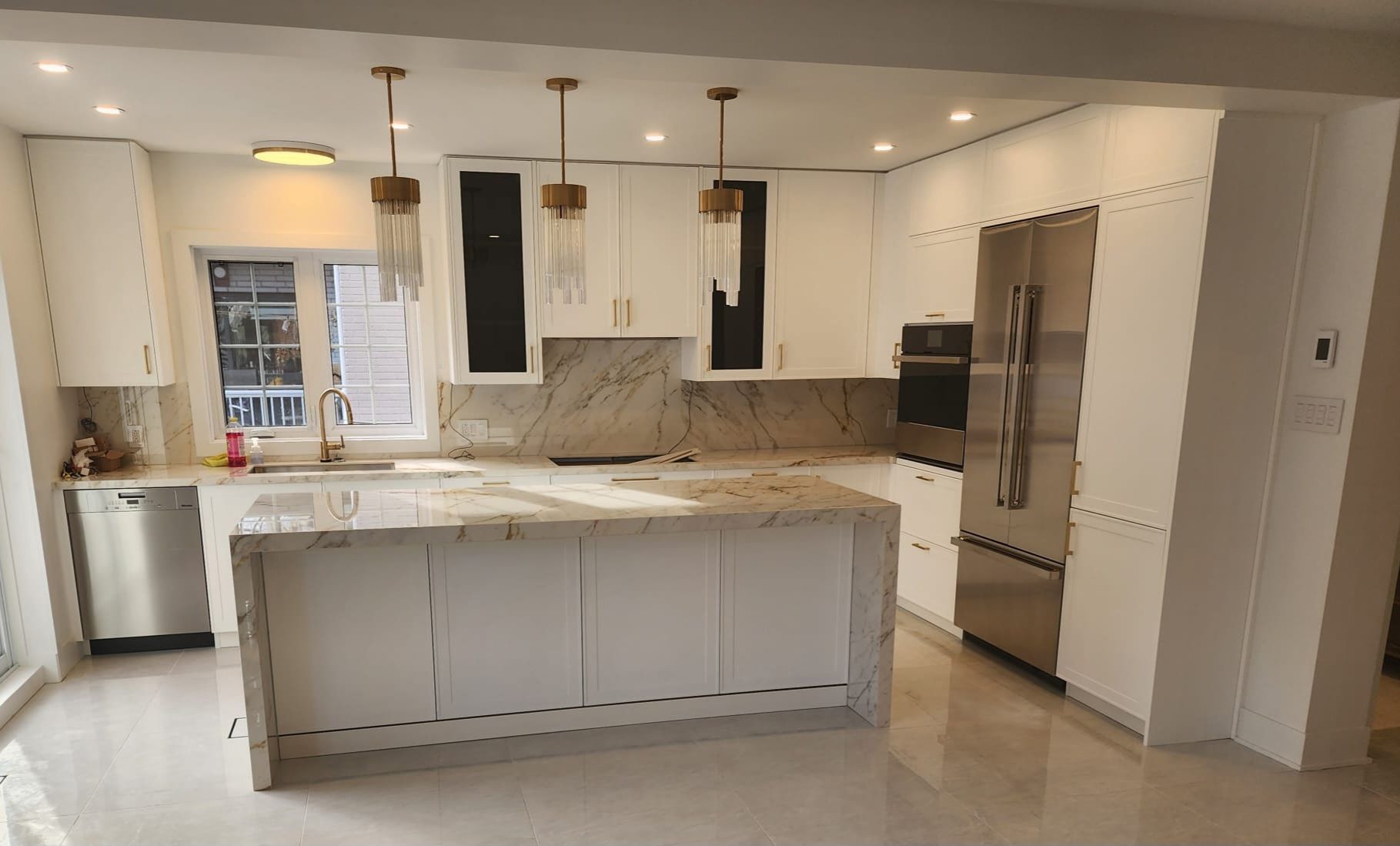 Cuisine blanche avec installation d'un nouvel évier, d'une crédence et de nouveaux placards.