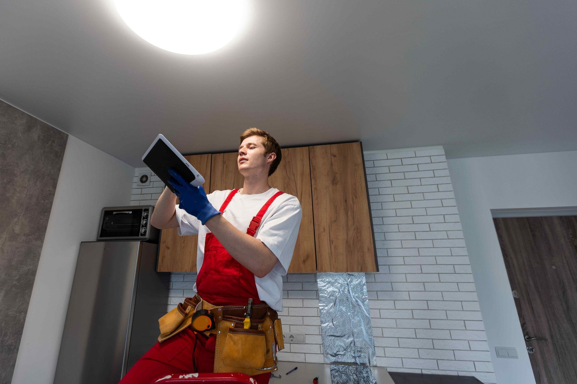 Electrician Installing Affordable LED Spotlights In Kitchen