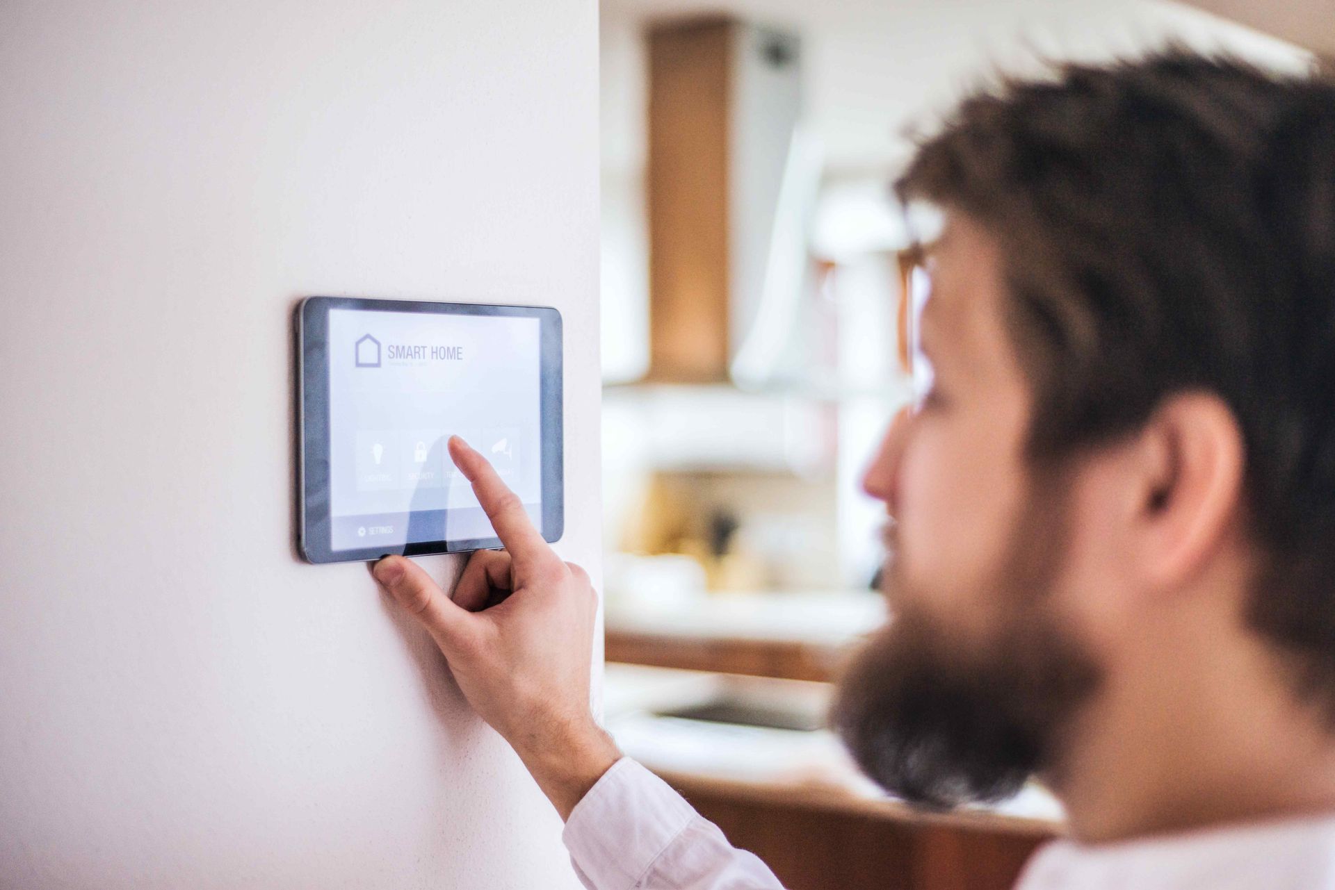 Man Controlling Affordable Smart Home From Tablet On Wall