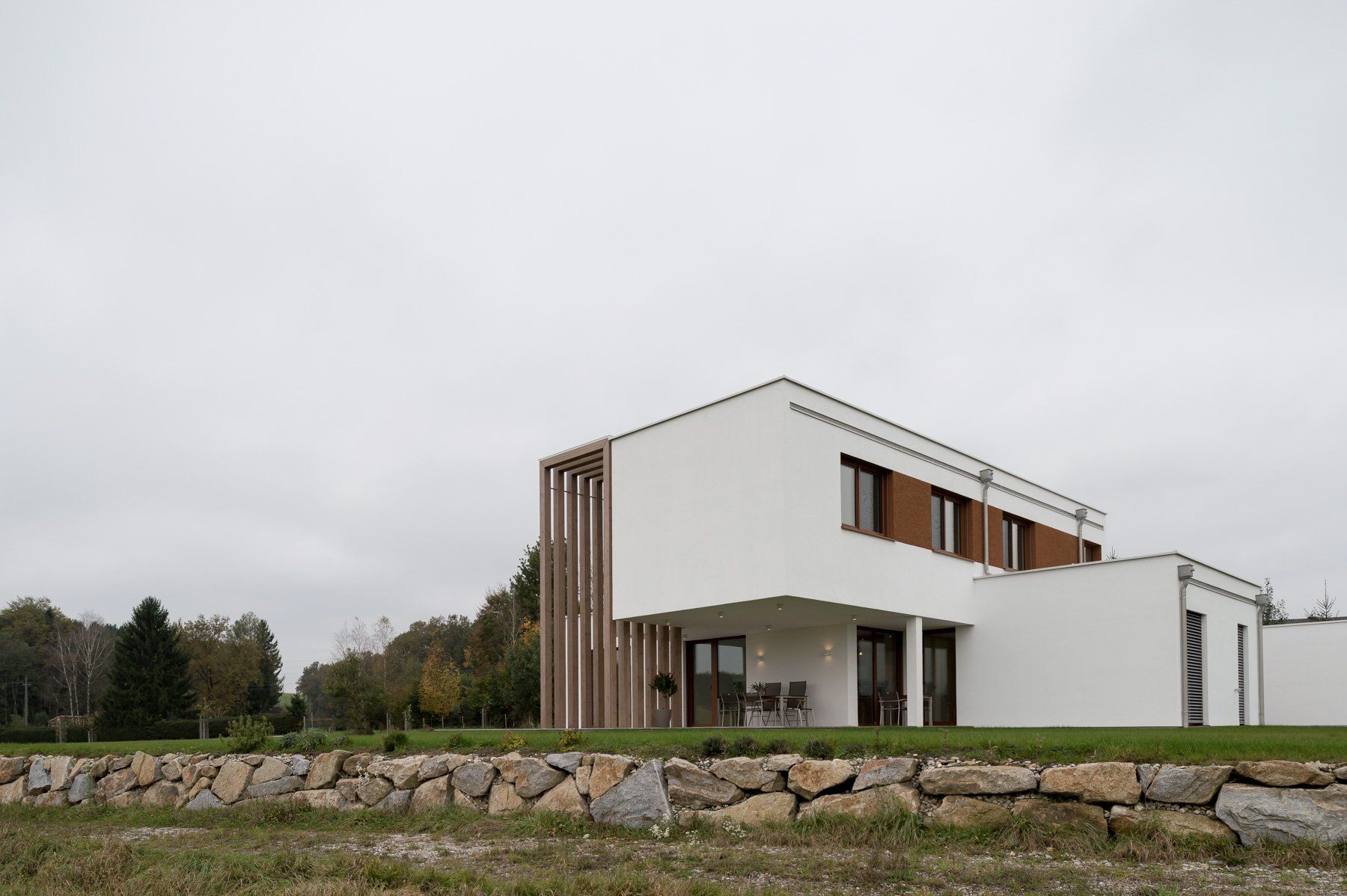 Ein weißes Haus mit einer Steinmauer davor